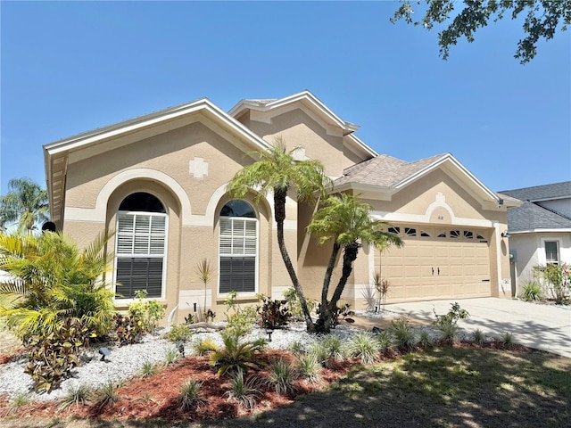 mediterranean / spanish house with concrete driveway, an attached garage, and stucco siding