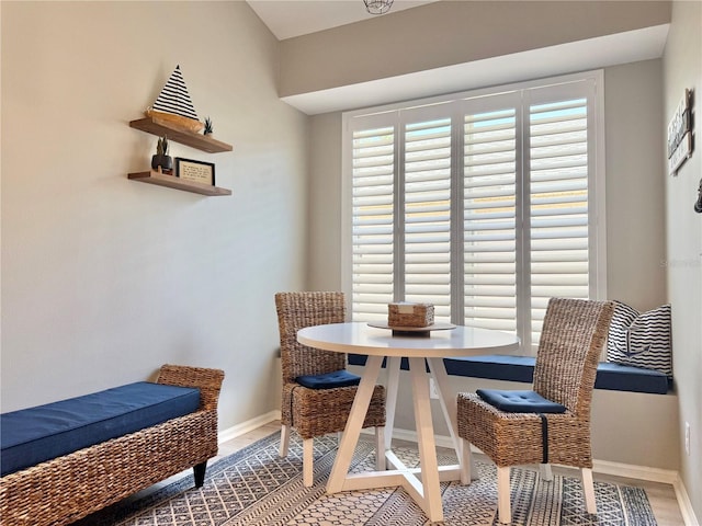 dining space with baseboards, wood finished floors, and a healthy amount of sunlight