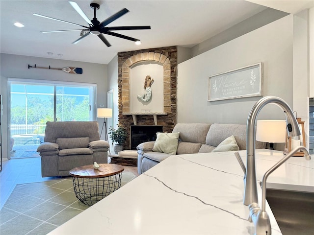 living area featuring recessed lighting, ceiling fan, and a fireplace