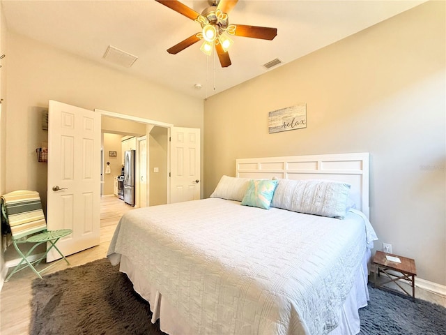 bedroom featuring visible vents, freestanding refrigerator, baseboards, and ceiling fan