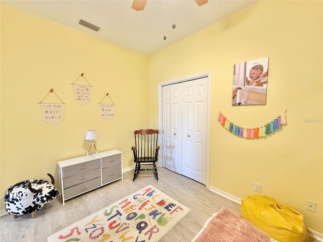 bedroom with light wood-type flooring, baseboards, visible vents, and a closet