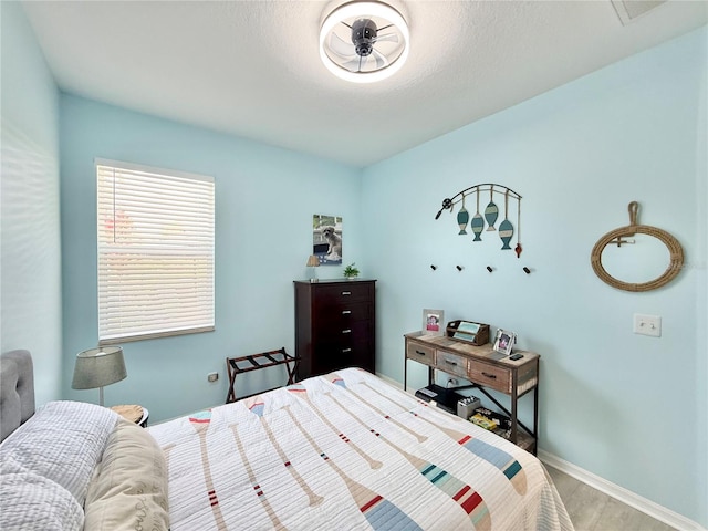 bedroom featuring baseboards and wood finished floors