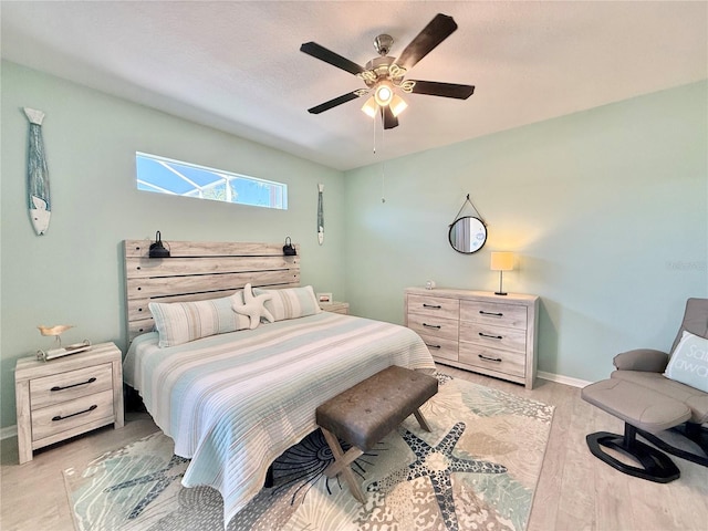 bedroom featuring light wood-style floors, baseboards, and ceiling fan