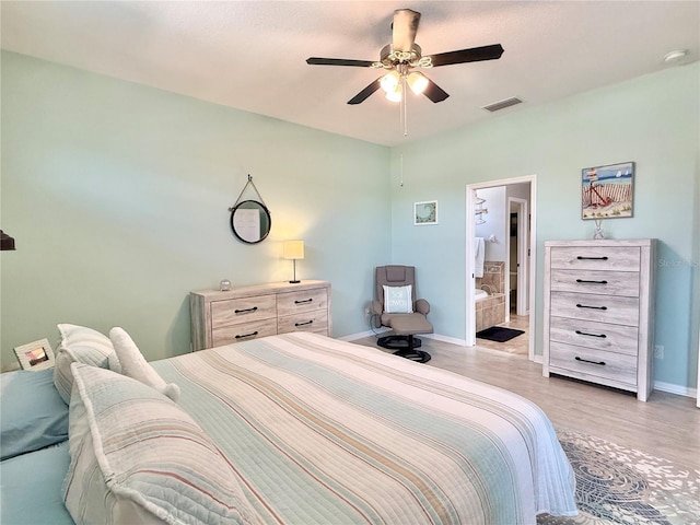 bedroom featuring visible vents, baseboards, ceiling fan, light wood-style flooring, and ensuite bath
