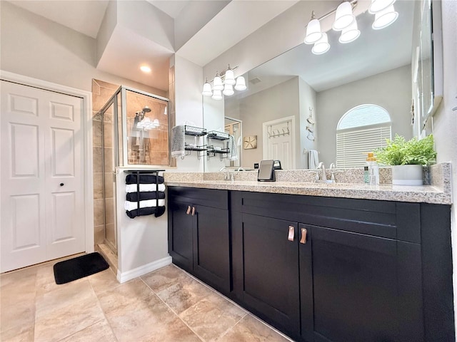 full bathroom featuring vanity, tile patterned floors, baseboards, and a stall shower
