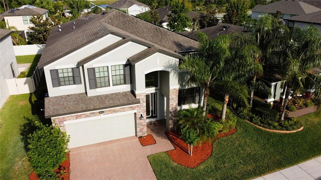 19314 Long Lake Ranch Blvd, Lutz, FL 33558 - view of front of house with stone siding, roof with shingles, decorative driveway, and stucco siding