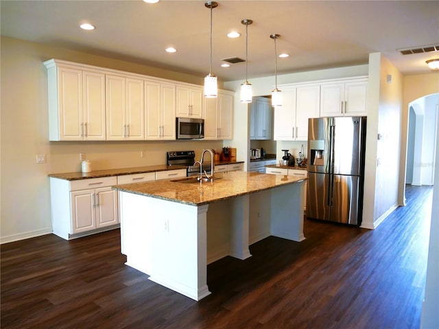 19314 Long Lake Ranch Blvd, Lutz, FL 33558 - kitchen featuring appliances with stainless steel finishes, a sink, arched walkways, dark wood finished floors, and white cabinets