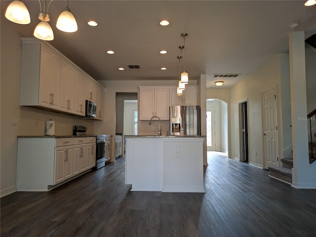 19314 Long Lake Ranch Blvd, Lutz, FL 33558 - kitchen featuring appliances with stainless steel finishes, recessed lighting, dark wood finished floors, arched walkways, and white cabinets