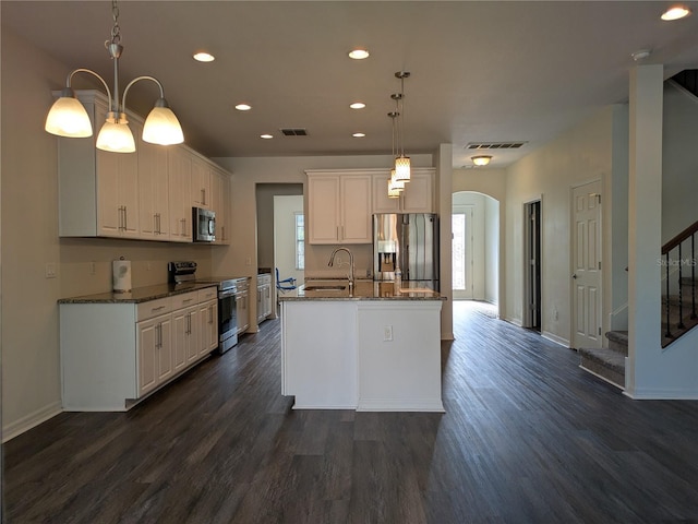 19314 Long Lake Ranch Blvd, Lutz, FL 33558 - kitchen featuring stainless steel appliances, arched walkways, recessed lighting, dark wood-style flooring, and a center island with sink