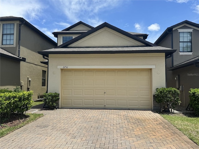 2731 Hampton Green Ln, Brandon, FL 33511 - view of front of house featuring stucco siding, decorative driveway, and an attached garage
