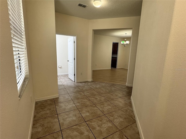 2731 Hampton Green Ln, Brandon, FL 33511 - hall with tile patterned flooring and a chandelier