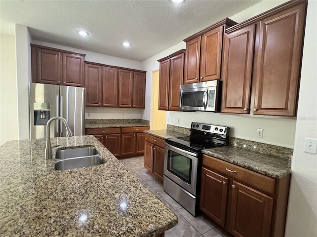 2731 Hampton Green Ln, Brandon, FL 33511 - kitchen with stainless steel appliances, tile patterned flooring, recessed lighting, a textured ceiling, and dark stone counters
