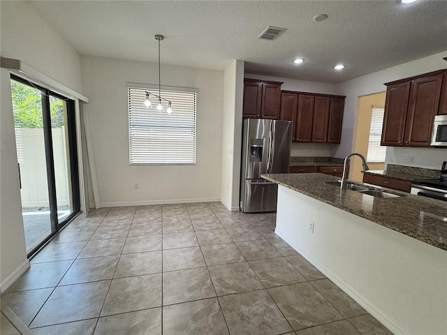 2731 Hampton Green Ln, Brandon, FL 33511 - kitchen with stainless steel appliances, dark stone counters, recessed lighting, a textured ceiling, and light tile patterned floors