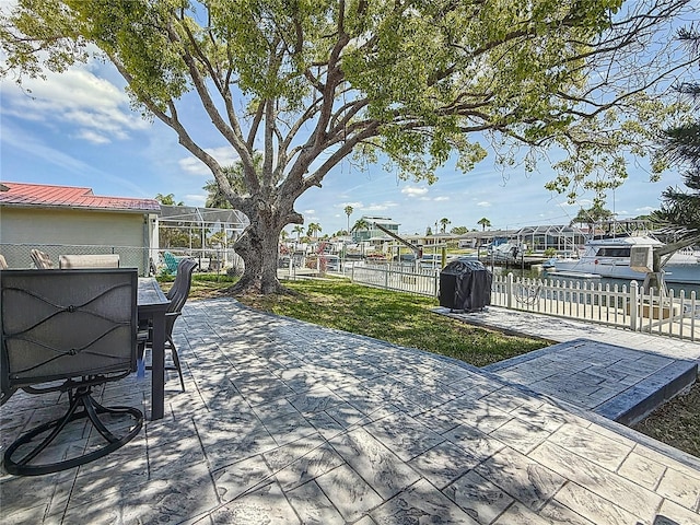 view of patio / terrace with fence private yard, a water view, and outdoor dining area