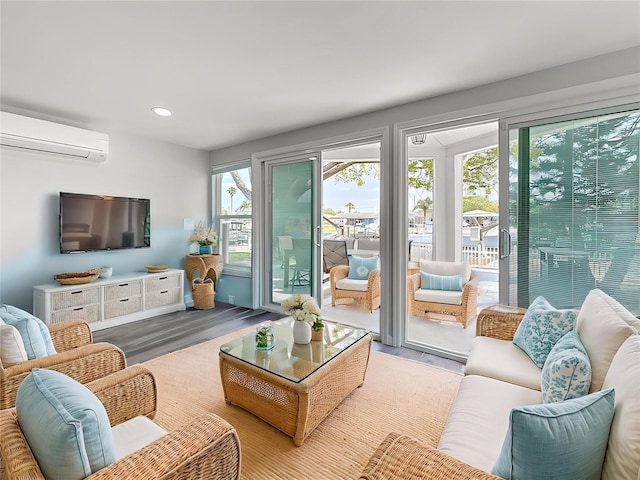living room featuring wood finished floors, recessed lighting, and a wall unit AC