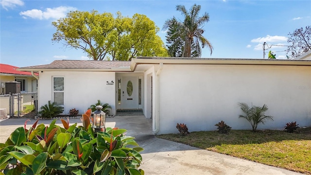 doorway to property featuring a gate and stucco siding
