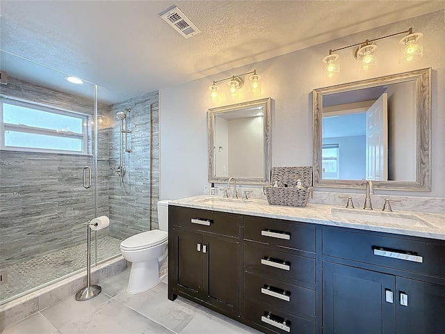 full bathroom featuring visible vents, a sink, a stall shower, and toilet
