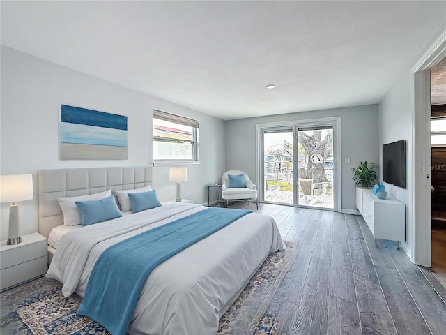 bedroom with baseboards, access to exterior, and wood finished floors