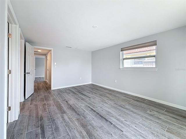 unfurnished bedroom featuring baseboards and dark wood finished floors
