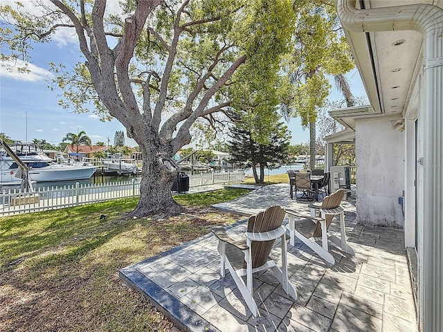view of patio / terrace with fence, outdoor dining space, and a water view