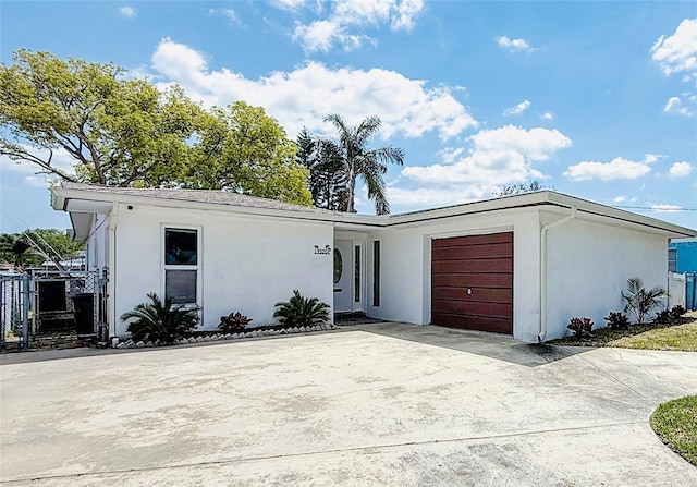 4920 Pelican Dr, New Port Richey, FL 34652 - view of front of home featuring stucco siding, an attached garage, and concrete driveway