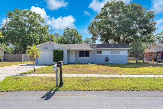 ranch-style home featuring a garage, a front lawn, fence, and concrete driveway