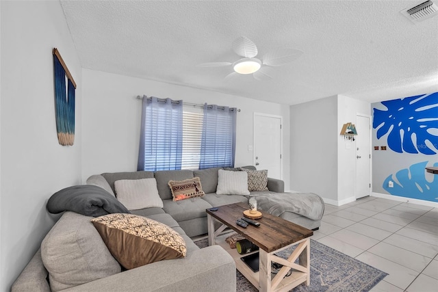 living room with baseboards, a ceiling fan, a textured ceiling, and visible vents