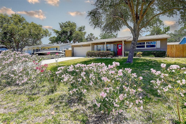 8497 137th St, Seminole, FL 33776 - ranch-style home with concrete driveway, fence, a front lawn, and a garage