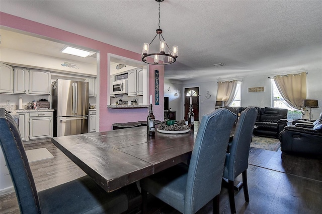 8497 137th St, Seminole, FL 33776 - dining area with wood finished floors, a textured ceiling, and a chandelier