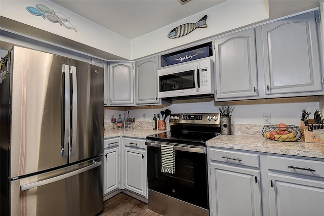 8497 137th St, Seminole, FL 33776 - kitchen featuring light countertops, stainless steel appliances, dark wood finished floors, and gray cabinetry