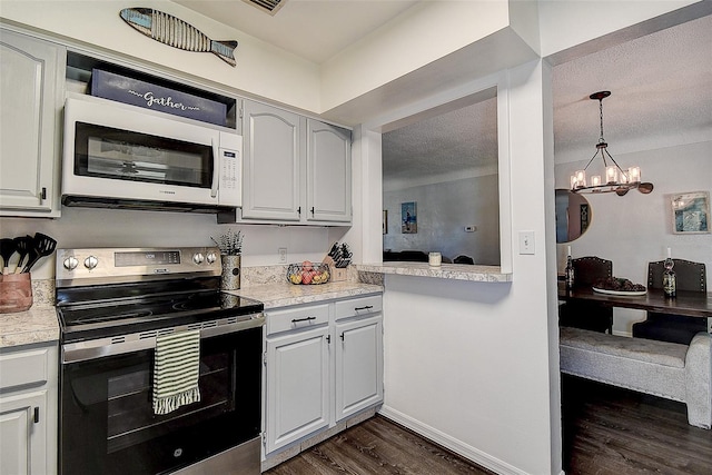 8497 137th St, Seminole, FL 33776 - kitchen with light countertops, white microwave, dark wood-style floors, and stainless steel electric range