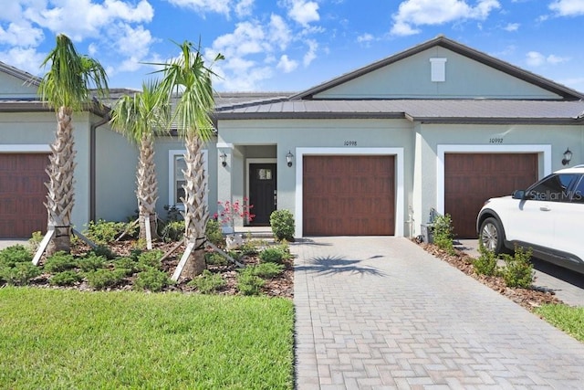 10998 Gable Dig Loop, San Antonio, FL 33576 - view of front facade with a garage, stucco siding, driveway, and a front lawn