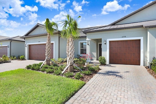 10998 Gable Dig Loop, San Antonio, FL 33576 - ranch-style home featuring a front lawn, stucco siding, an attached garage, and decorative driveway