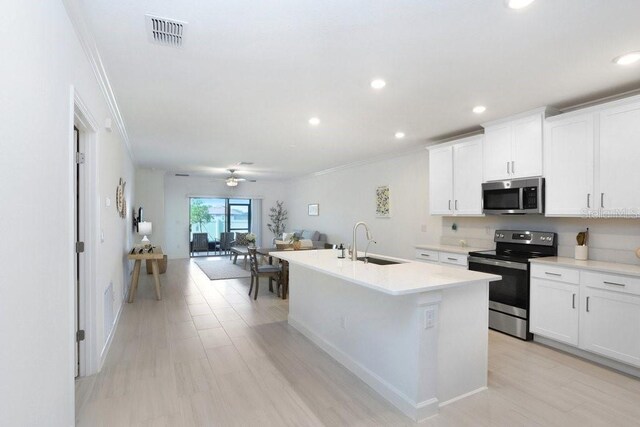 10998 Gable Dig Loop, San Antonio, FL 33576 - kitchen featuring a sink, ornamental molding, stainless steel appliances, and visible vents