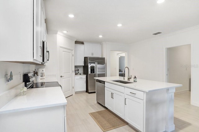 10998 Gable Dig Loop, San Antonio, FL 33576 - kitchen featuring appliances with stainless steel finishes, a sink, a kitchen island with sink, white cabinetry, and ornamental molding