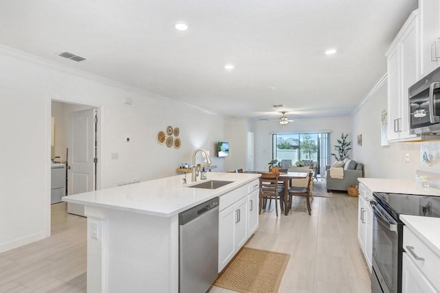 10998 Gable Dig Loop, San Antonio, FL 33576 - kitchen with visible vents, a sink, ornamental molding, stainless steel appliances, and an island with sink