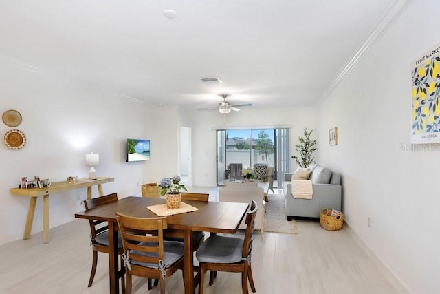 10998 Gable Dig Loop, San Antonio, FL 33576 - dining space with ceiling fan, visible vents, crown molding, baseboards, and light wood finished floors