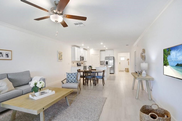 10998 Gable Dig Loop, San Antonio, FL 33576 - living area featuring crown molding, ceiling fan, recessed lighting, light wood-type flooring, and visible vents