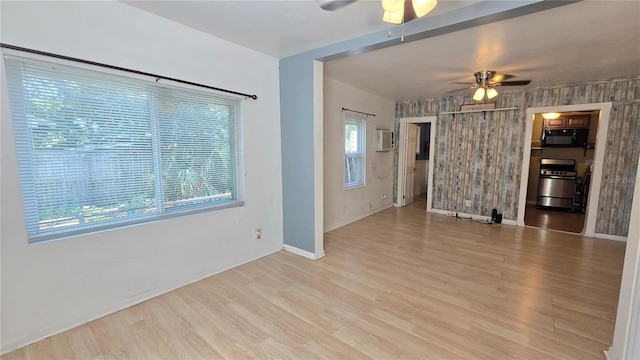 342 N 40th St N, Saint Petersburg, FL 33713 - unfurnished living room with baseboards, ceiling fan, wood finished floors, and a wall unit AC