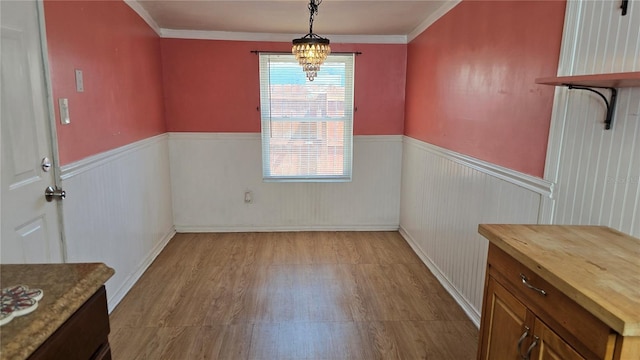 342 N 40th St N, Saint Petersburg, FL 33713 - unfurnished dining area with crown molding, an inviting chandelier, wood finished floors, and a wainscoted wall