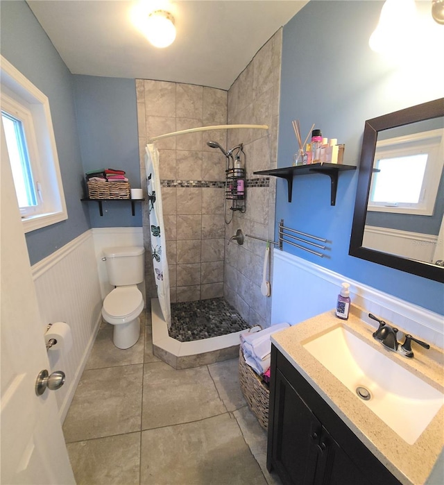 342 N 40th St N, Saint Petersburg, FL 33713 - bathroom featuring tile patterned flooring, wainscoting, a shower stall, vanity, and toilet