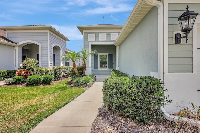 property entrance featuring a lawn