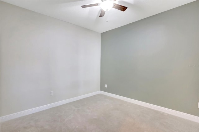 empty room featuring baseboards, ceiling fan, and light colored carpet