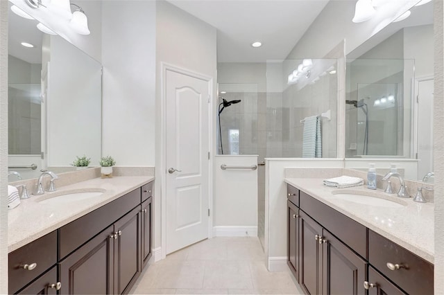 full bathroom with a sink, a walk in shower, tile patterned floors, and two vanities