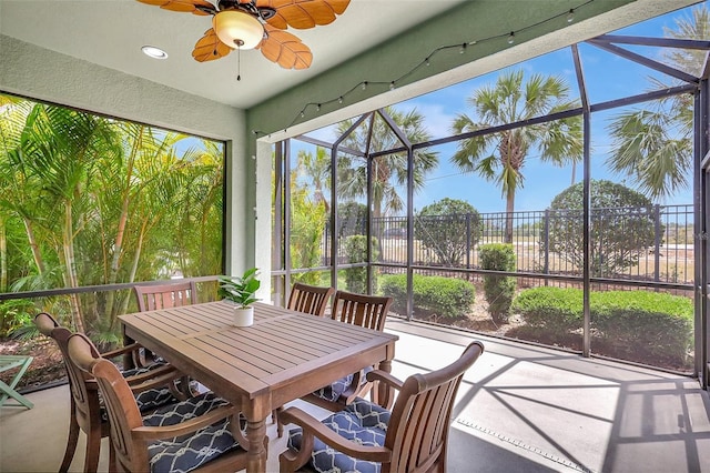 sunroom / solarium with a ceiling fan and outdoor dining space