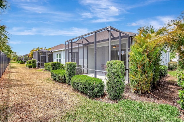 rear view of property featuring a yard and a lanai