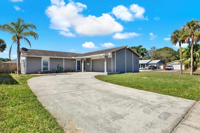 view of front facade featuring a garage, a front lawn, fence, stucco siding, and driveway