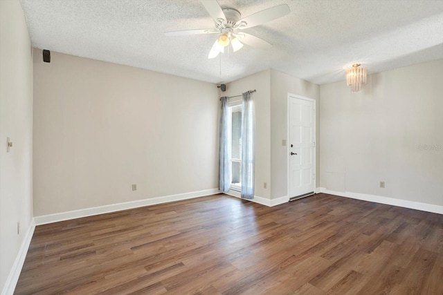 empty room with baseboards, ceiling fan, a textured ceiling, and wood finished floors