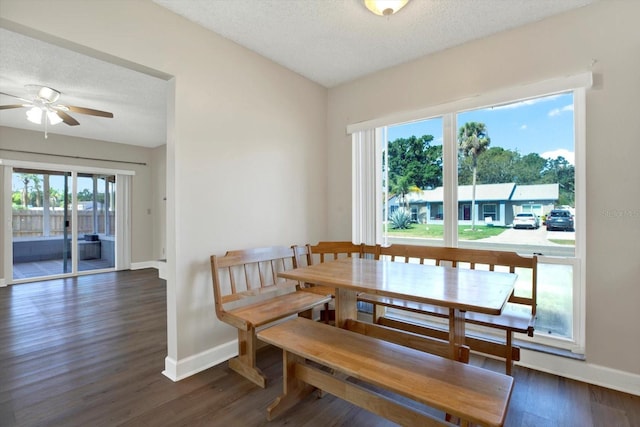 dining area with baseboards, a ceiling fan, dark wood finished floors, and a textured ceiling