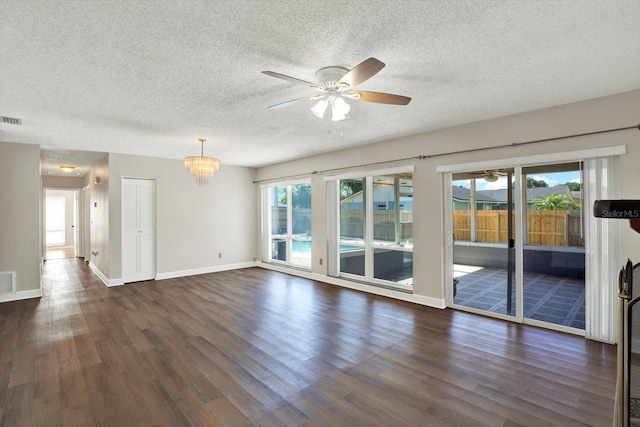 interior space featuring a textured ceiling, dark wood finished floors, and ceiling fan with notable chandelier